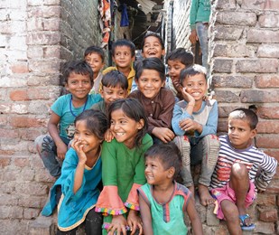 Group of young children in India sat laughing