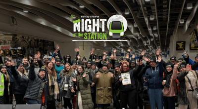 A crowd of people in a train station. Text reads: Railway Children Night at the Station.