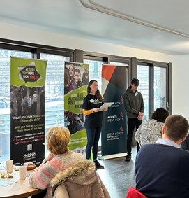 A woman stood giving a talk to a group.