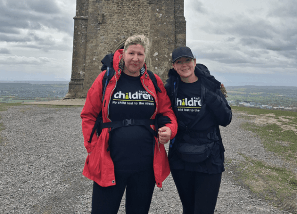 Two females at the top of a hill wearing winter clothing and Railway Children T-shirts.