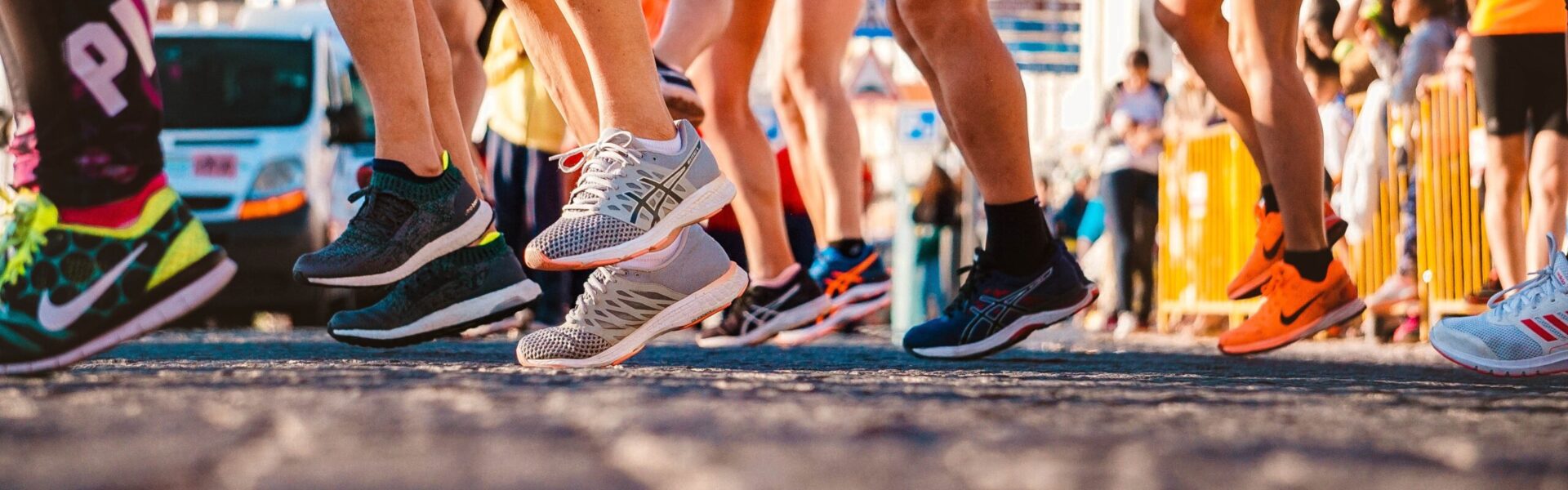 Photo of runners legs and running shoes in a line ready for a race.