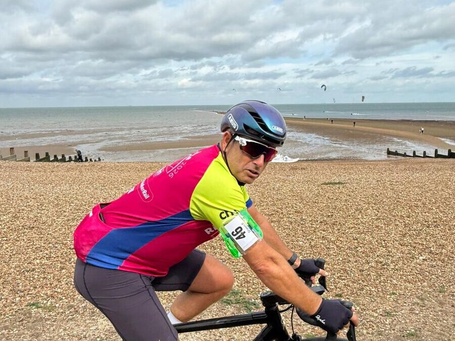 A cyclist riding past a beach in the UK during Railway Children's Ride the Route challenge.