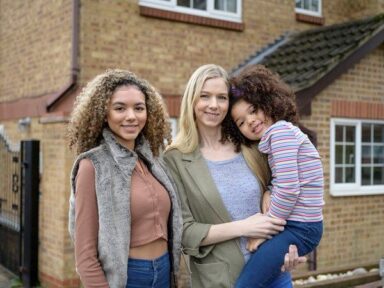 Mother and her daughters stood outside her house.