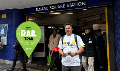 Man wearing circle line white t-shirt, stood outside Sloane Square Station.
