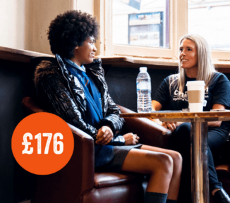 Teen girl in school uniform sat with a blonde project worker having a coffee.