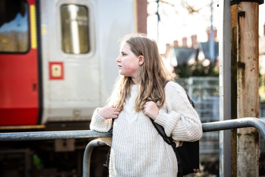 Young blonde girl waiting for a train.