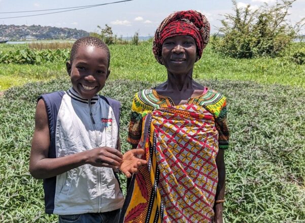 Grandmother stood with her granddaughter in a field.