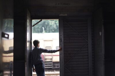 Back of child on train looking out of open door