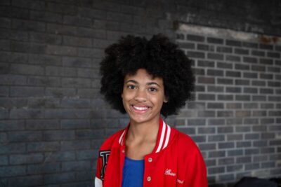 Girl looking at camera and smiling, wearing red jacket