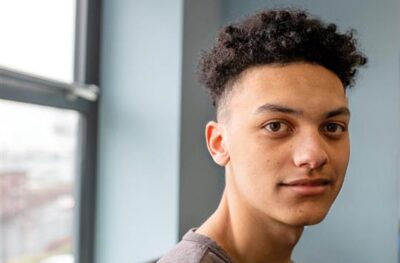 Teenager looks at camera slightly smiling