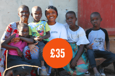 Family and project worker in Tanzania looking at camera and smiling
