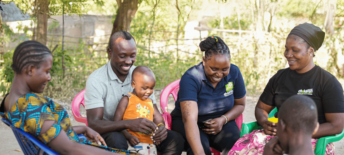 Two Railway Children Africa family workers sat with a father, mother and their two daughters.