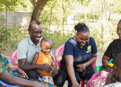 Two Railway Children Africa family workers sat with a father, mother and their two daughters.