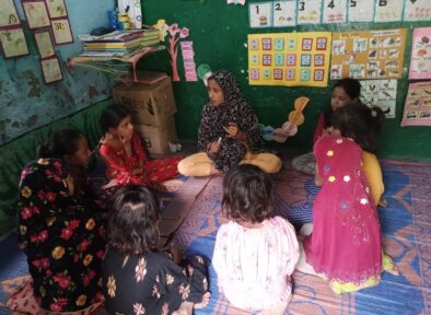 Image of community champion sitting with the young people in India.