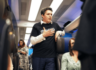 Huw Merriman talking to guests on a train