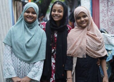 Three girls stood smiling for the camera.
