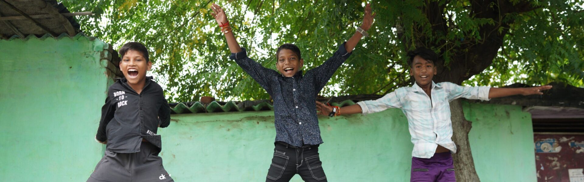 Three boys jumping in the air.