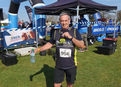 man stood at a finishing line at half marathon for Railway Children.