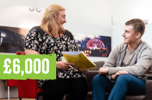 A teenage boy sat on a sofa next to a social worker. They are both smiling and talking to each other. The social worker is holding a document and showing the boy. Text on image reads: £6,000.