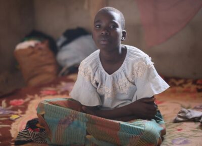 Young girl sat on the floor.