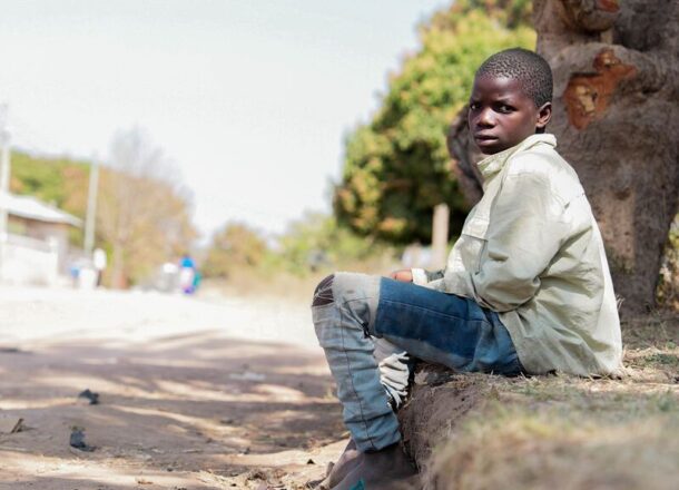 African child sitting on street