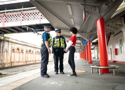 British transport police officers speaking to young person on train platform