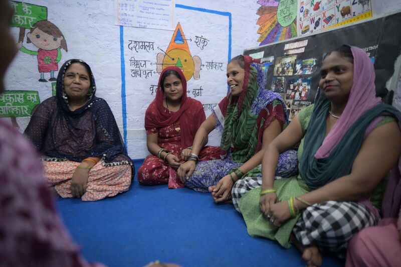 Indian family sitting on floor smiling and laughing