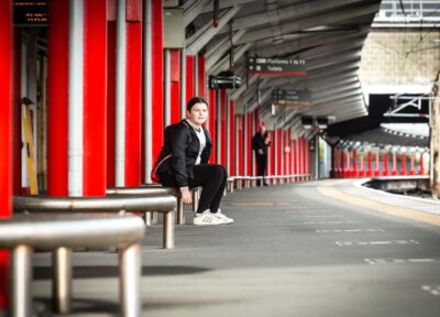 Young teenage girl sitting on train station platform