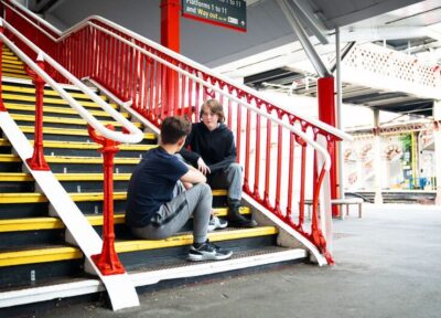 Young teenagers sitting on station stairs signs of exploitation