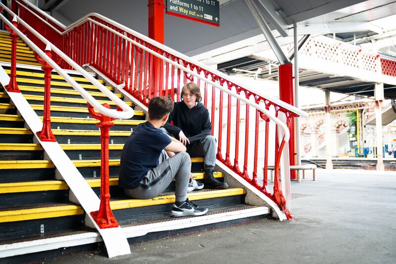 Young teenagers sitting on station stairs signs of exploitation