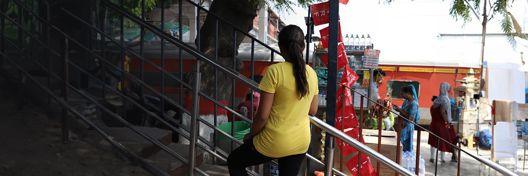 Young girl with a yellow t-shirt on - with her back to the camera.