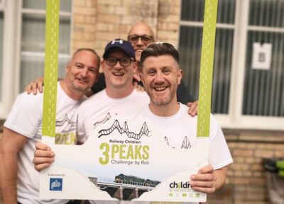 Three Peaks by Rail participants take photo with Railway Children frame