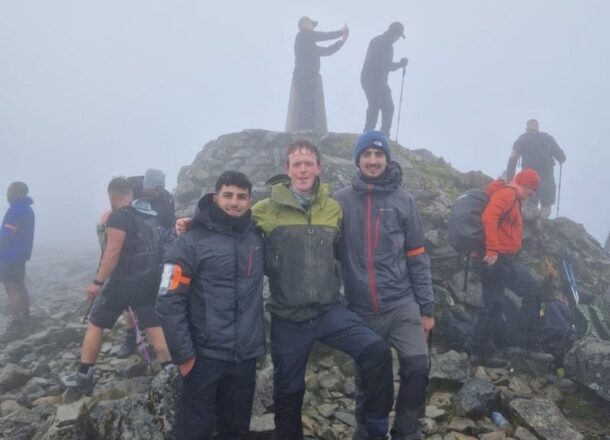 Yorkshire Three Peaks participants posing on mountain with misty background.