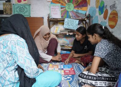 A group of girls sat in a classroom in India playing an educational game/