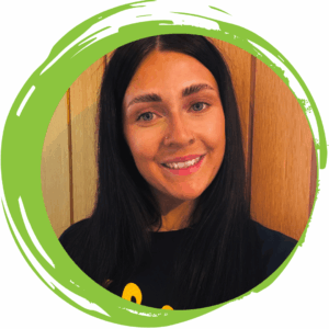 An image of a woman with dark brown hair smiling and wearing a black T-shirt with a green circle frame surrounding her.