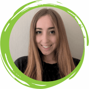 An image of a woman with dark blonde hair smiling and wearing a black T-shirt with a green circle frame surrounding her.