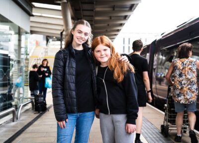 Teenage girls smiling on train platform