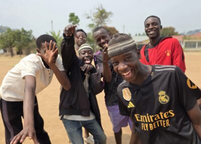 A group of young adults in Tanzania celebrating and wearing various colours.