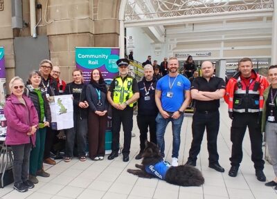 A group of rail industry colleagues with a Railway Children community engagement worker at a railway station in the UK.