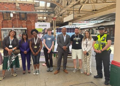 A group of people from across the rail industry raising awareness at a train station in the UK.