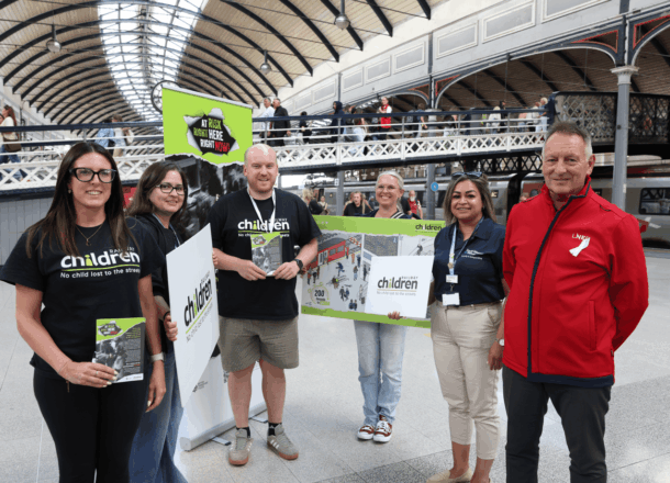 A group of individuals from Railway Children, LNER and Avanti West Coast promoting safeguarding awareness at a train station in the UK.