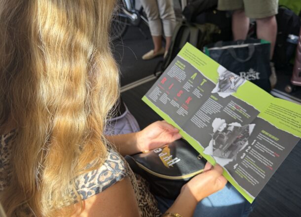 A person reading Railway Children safeguarding materials during an awareness event on the rail network.