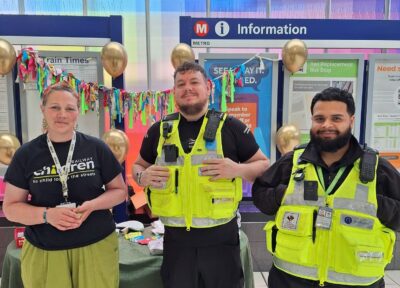 A Railway Children community engagement worker with British Transport Police officers at a Bradford Mela stall.