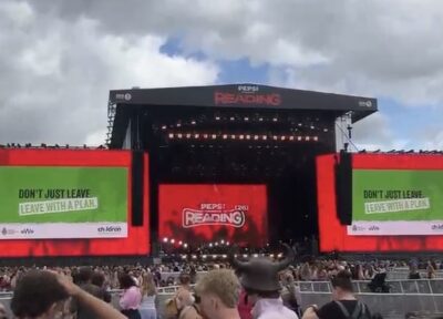 A stage at Reading festival with screens either side showing Railway Children branded messaging.