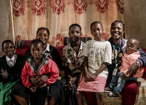 Children and trusted caregivers together in a home environment, representing child welfare, family support services