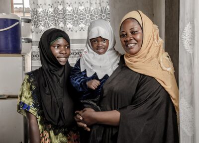 Family in a home environment representing the impact of community development initiatives and child-focused support programmes.