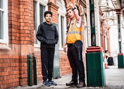Young person on railway station platform benefiting from charitable initiatives that create opportunities for learning, growth and community support.
