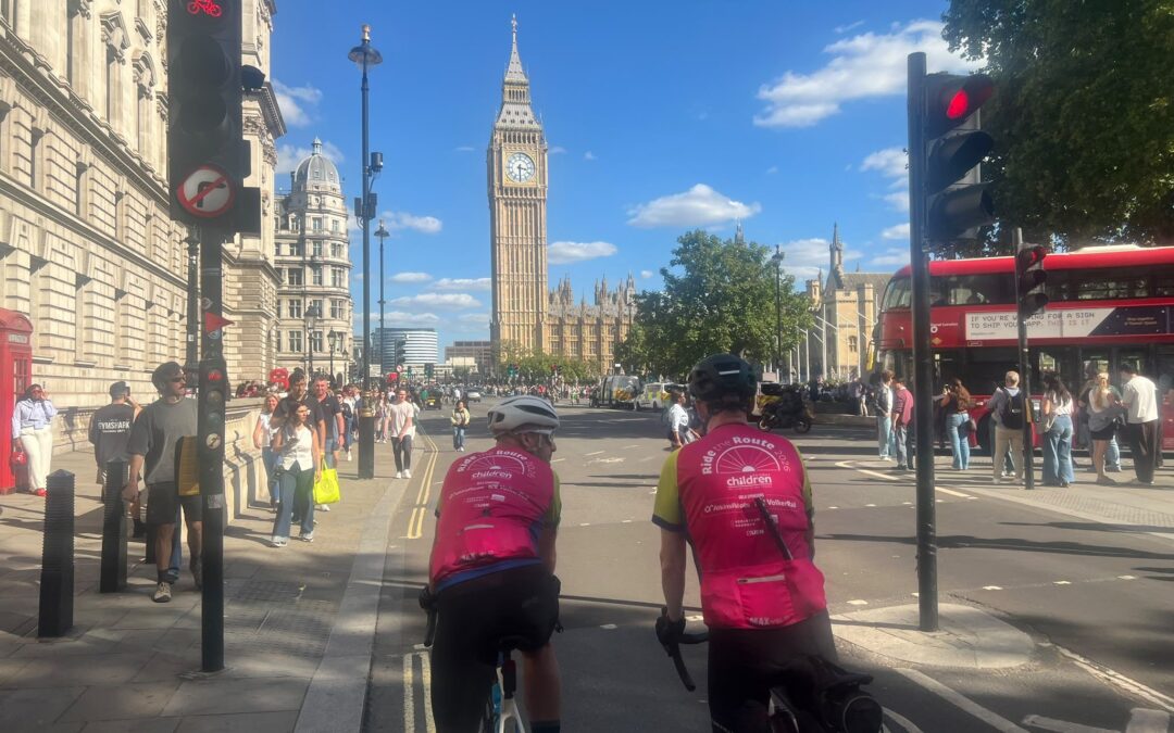 Cyclists in front of the Elizabeth Tower in London during Ride the Route wearing brightly coloured jerseys.