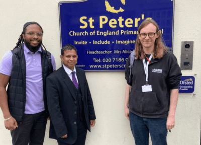 Staff from St Peter's primary school outside their building with a community engagement worker from Railway Children.