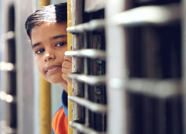 Child looking from a train carriage, highlighting the impact of charitable donations on education, child wellbeing and future opportunities.